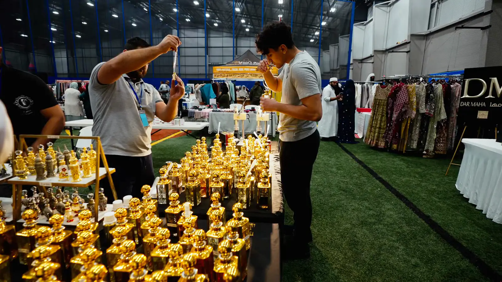 A vendor filling attar bottles at his bazaar stall