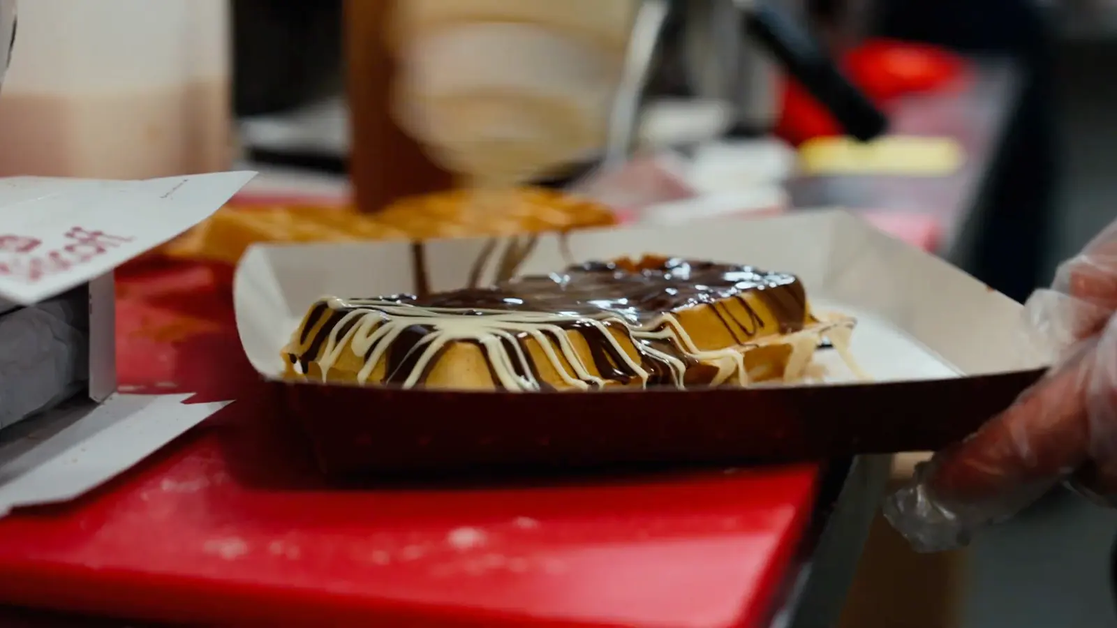 A dessert plate handed across a vendor counter