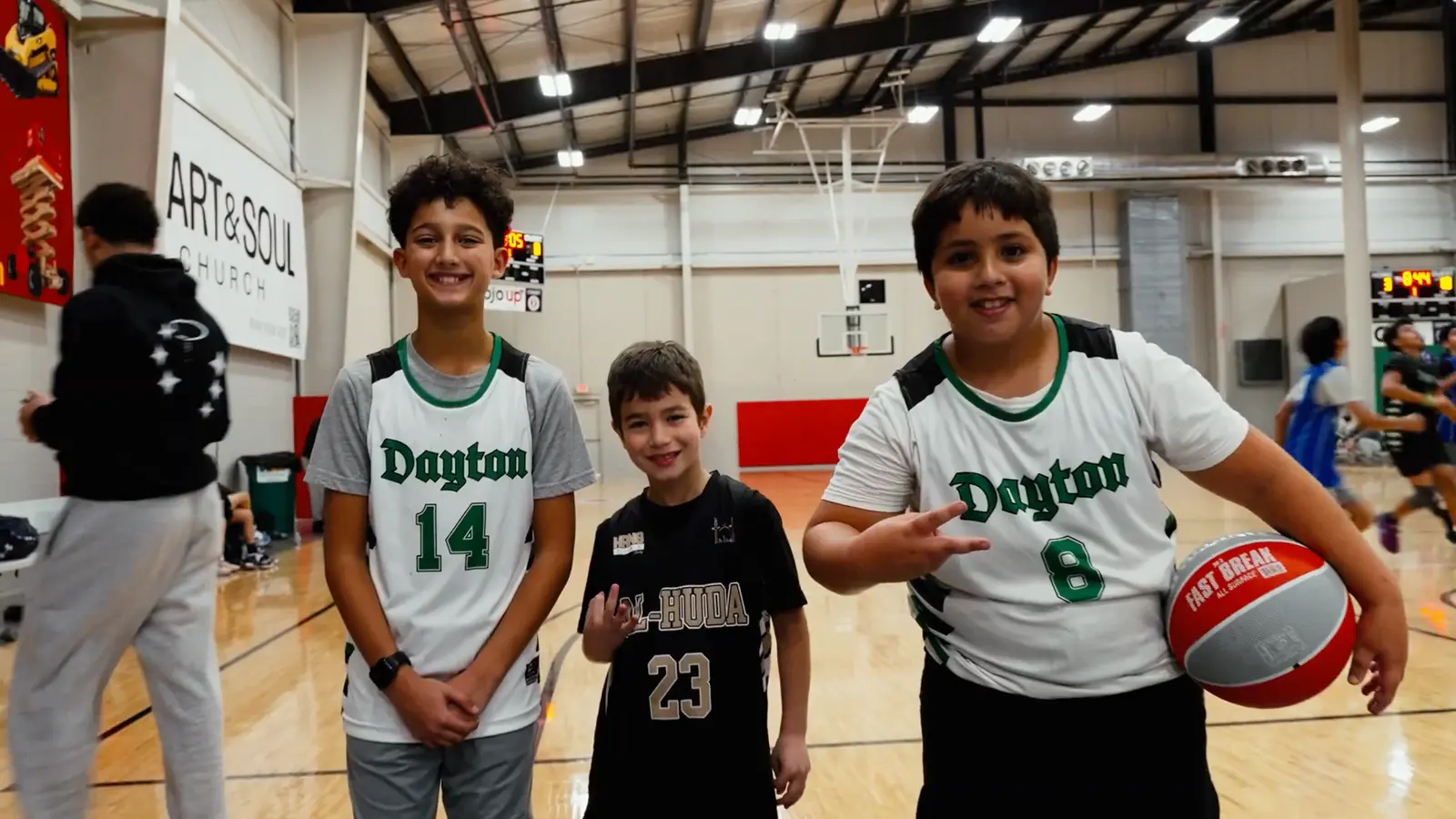 Three young players holding a basketball between games