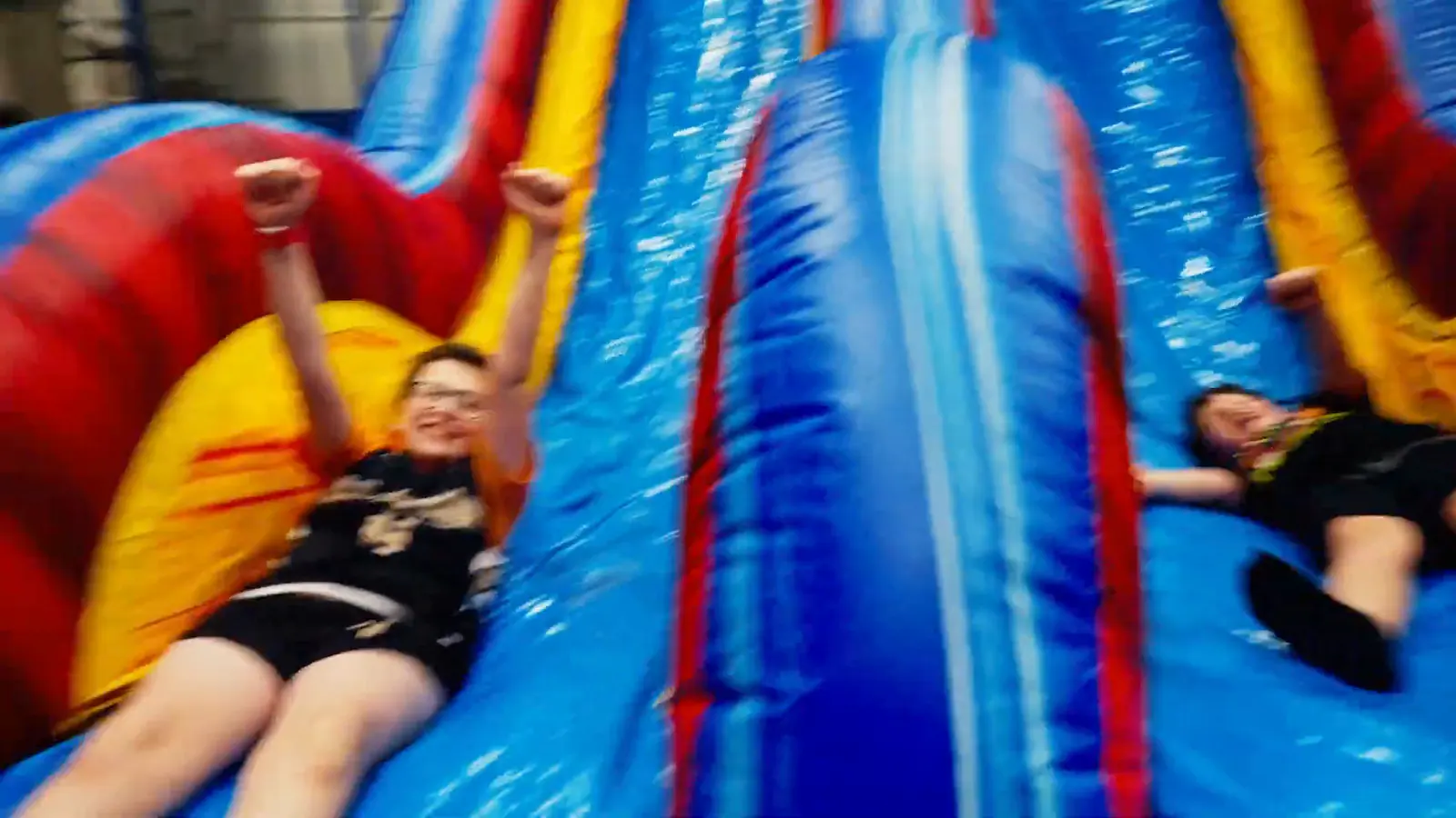 A child mid-slide on the inflatable course